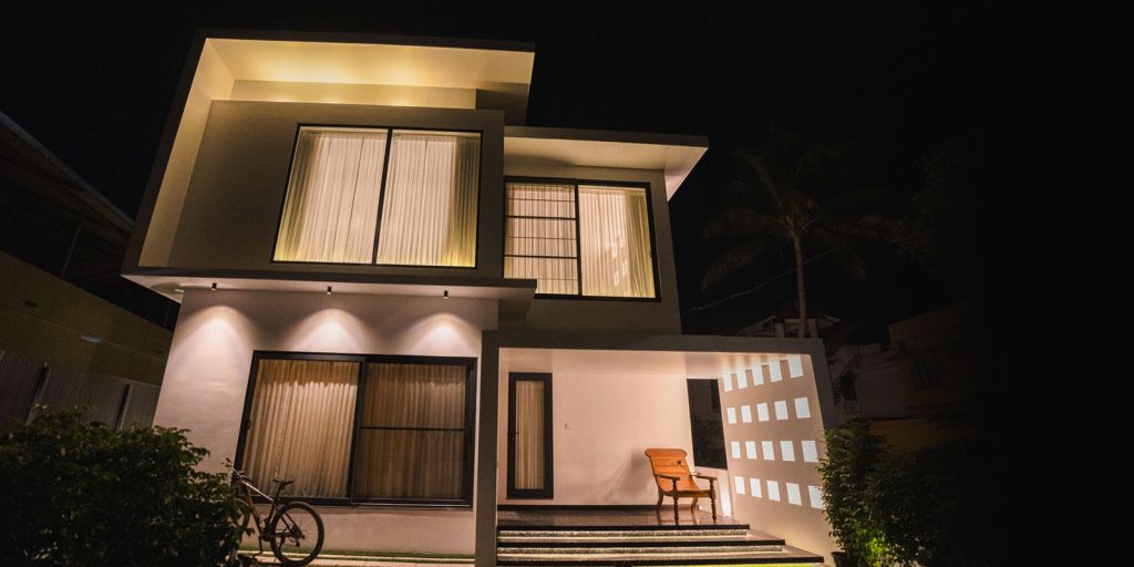 alt="Contemporary modern home exterior with large glass windows and flat roof